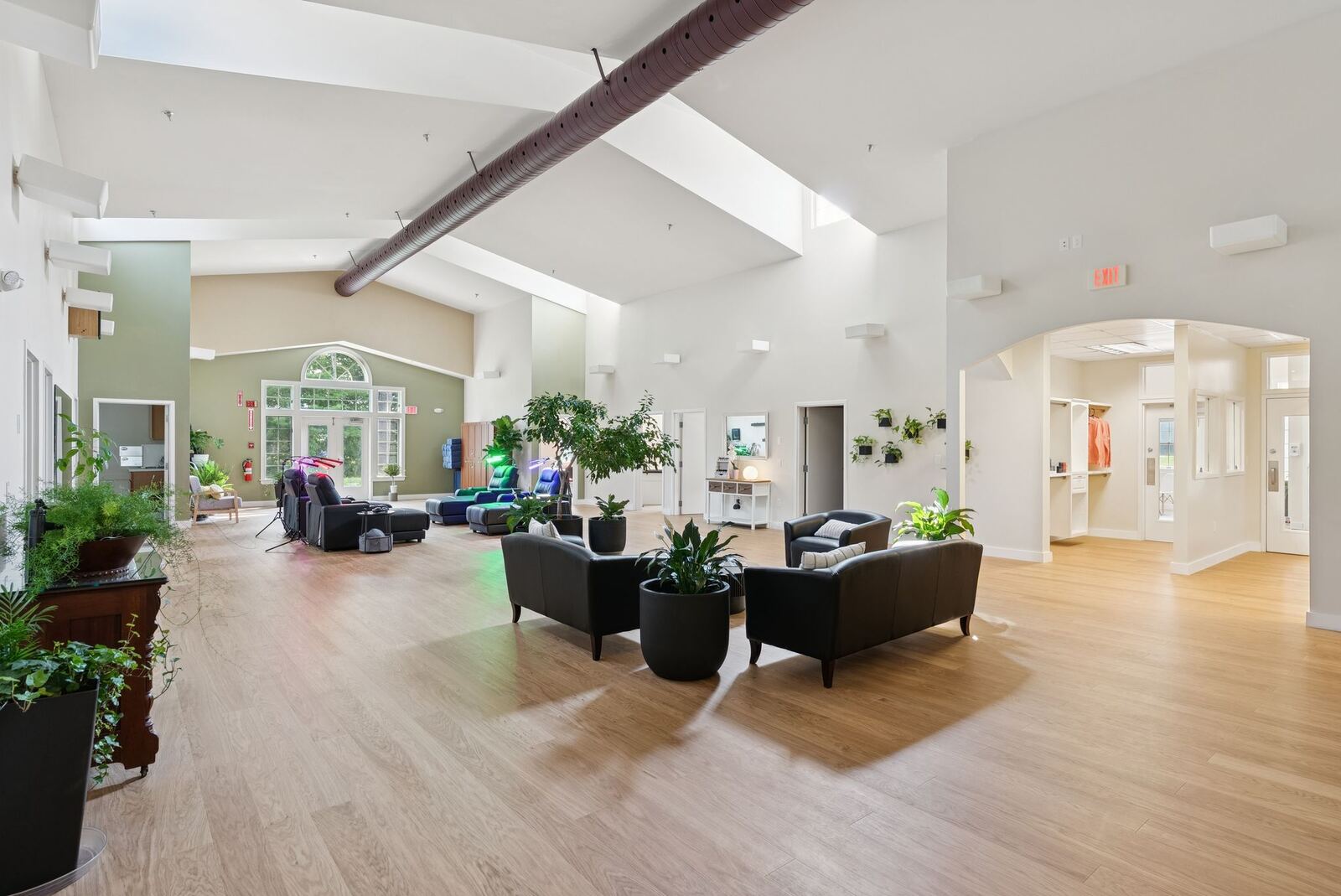 Main wellness lounge with vaulted ceilings and red light therapy chairs